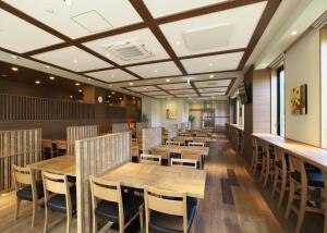 EchizenHotel Route-Inn Takefu Inter的用餐室配有木桌和椅子