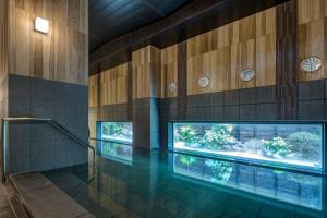 千叶HOTEL ROUTE-INN Chiba Hamano -Tokyowangan doro-的一座带木墙的建筑中的游泳池