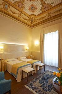 佛罗伦萨佛罗伦萨卡皮塔尔酒店的酒店客房设有两张床和天花板