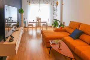 莱昂Housingleon- Casa Oliva con Garaje的客厅配有橙色沙发和桌子