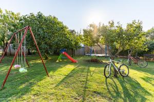斯桑Holiday Home Kerniat的草地上带两只秋千和两辆自行车的院子