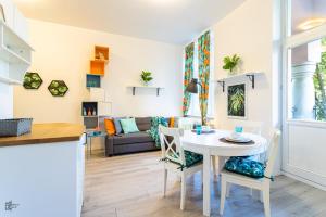 索波特Victus Apartamenty, Apartamenty Alicante的厨房以及带桌椅的起居室。