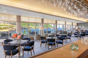 英雄港特塞拉岛马尔酒店的餐厅设有桌椅和窗户。