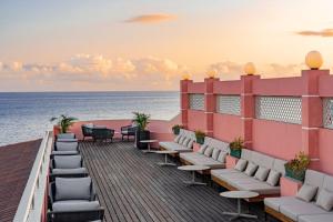 英雄港特塞拉岛马尔酒店的阳台配有椅子,背靠大海
