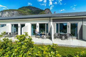 瓦尔河谷Valldal Fjordhotell - by Classic Norway Hotels的坐在房子庭院里的人