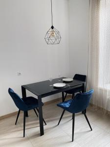 罗夫诺VIP Apartment Rovno & Новобудова ЖК Театральний Центр的一张黑色餐桌和两张蓝色椅子
