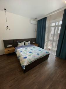罗夫诺VIP Apartment Rovno & Новобудова ЖК Театральний Центр的一间卧室配有床和蓝色窗帘的窗户
