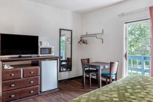 李城李城伊克诺旅馆 - 大巴灵顿的一间卧室配有电视和一张桌子