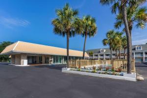 帕瓦雷斯岛Quality Inn & Suites的停车场前方的棕榈树建筑