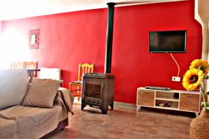 波凯兰特Casa Rural Bekirent的一间带炉灶和红色墙壁的客厅