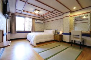 台北凤凰阁温泉饭店的一间卧室配有一张床、一张桌子和一面镜子