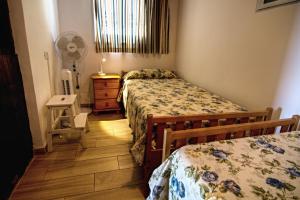 阿罗纳Casa Capitan con vista mar的一间带两张床和风扇的小卧室
