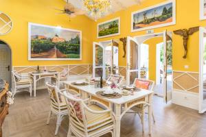 厄尔普伊格Maison San Alfredo B&B的用餐室设有黄色的墙壁和桌椅