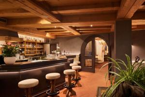 拉维拉Dolomites Wellness Hotel Savoy的餐厅的酒吧,带凳子