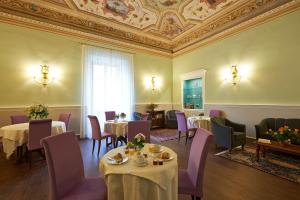 佛罗伦萨佛罗伦萨卡皮塔尔酒店的一间带桌椅和天花板的用餐室