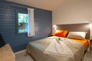 蓬他码头Adriano Family Camping Village的一间卧室配有一张蓝色墙壁的床