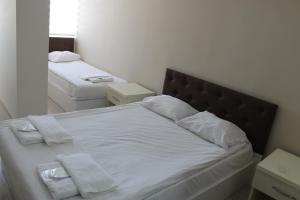 安卡拉阿布罗内卡提贝酒店的一间卧室配有带白色床单和毛巾的床。