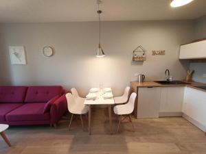 弗热希尼亚Apartamenty Września的客厅配有紫色的沙发、桌子和椅子