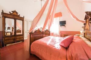 雷妮Villa Mariella Pittorino - camere in B&B的一间卧室配有一张天蓬床和梳妆台