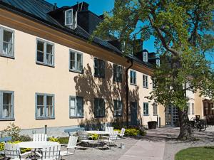 斯德哥尔摩Hotel Skeppsholmen, Stockholm, a Member of Design Hotels的一组桌子和椅子,位于大楼前
