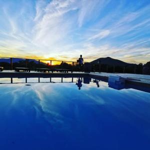 蒙特雷ETCHE ARGUINIA CHAMBRES HOTES的日落时站在游泳池旁的人