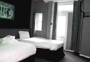 布莱克浦游乐海滩亨森酒店的带2扇窗户的客房内的2张床