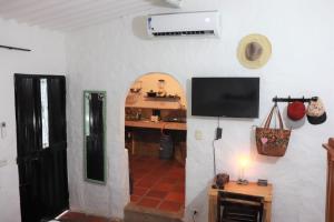 塔甘加Casa de Piedra Taganga的一间客厅,在白色的墙上配有电视
