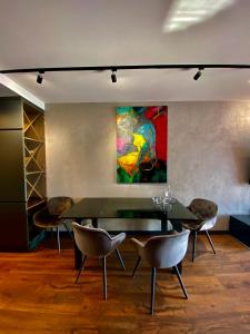 拉多姆Aparts Hotel Radom的一间带桌椅和绘画的用餐室