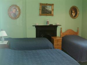 邓莱里克莱蒙特之家旅馆的一间卧室设有两张床和一个壁炉