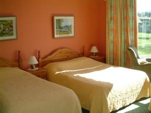 邓莱里克莱蒙特之家旅馆的卧室设有两张床铺和橙色墙壁