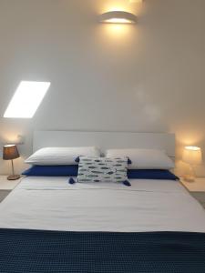 威尼斯丽都Cottage al mare Martina的一间卧室配有一张带两盏灯的大型白色床。