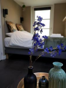 斯霍尔Studio Klein Schoorl的卧室里一张桌子上花草的花瓶