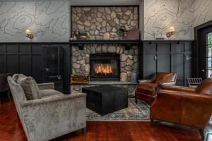 North CreekThe Alpine Lodge的客厅设有石制壁炉和家具。