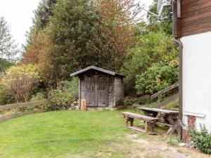 EisfeldChalet in Hinterrod Thuringia with sauna的院子中的木棚和长凳
