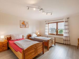 基希洪德姆Vacation home with garden in beautiful Sauerland的一间卧室设有两张床和窗户。
