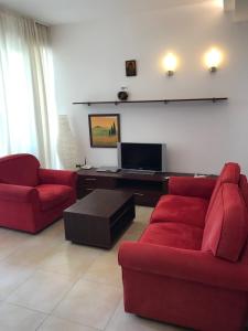 比亚拉Exclusive Big Villa的客厅配有2张红色沙发和电视