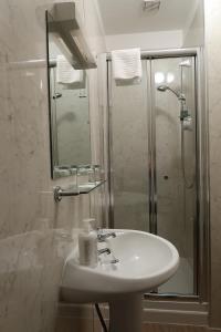 因弗内斯科伦纳花园小屋住宿加早餐旅馆的白色的浴室设有水槽和淋浴。