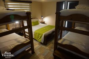 圣罗莎德卡瓦尔Hotel Termales San Vicente的一间卧室配有三张双层床。