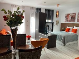 塞维利亚Apartamentos "El Escondite de Triana"的客厅配有一张床和一张花瓶桌子