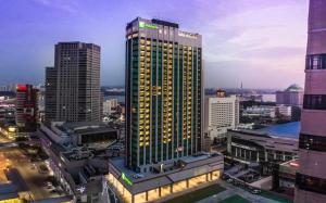 新山Holiday Inn Johor Bahru City Centre, an IHG Hotel的一座高大的建筑,城市里灯火通明