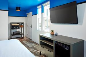圣地亚哥浪琴旅馆的一间卧室配有一张床和一台平面电视