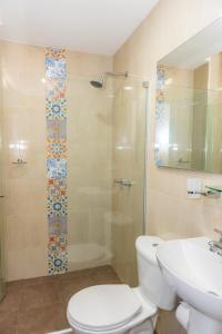 巴兰基亚卡萨加勒比殖民公寓的浴室配有卫生间、淋浴和盥洗盆。