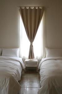 鹅銮鼻窝在海边民宿的带窗户的客房内的两张床