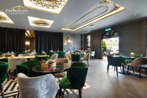 金马仑高原Zetter Suites @ Cameron的一间餐厅,房间内设有绿色的椅子和桌子