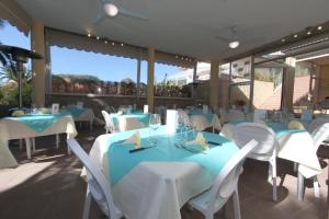 阿祖罗港旺达别墅酒店的一间设有蓝色和白色桌椅的餐厅