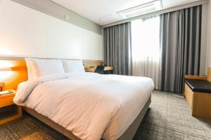 天安市开城大酒店 的一间设有大床和窗户的酒店客房