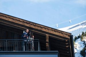奥伯古格尔Gletscherblick- serviced apartments的一个人站在一个有滑雪板的阳台上