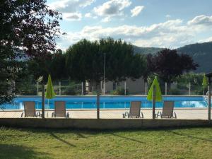 Saint-Julien-de-LamponCamping Le Mondou的一组椅子和遮阳伞,位于游泳池旁
