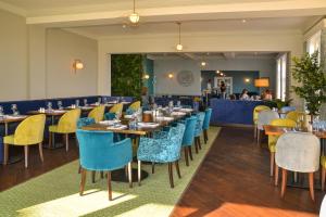 滨海克拉克顿金斯克利夫酒店的餐厅设有蓝色和黄色的椅子和桌子