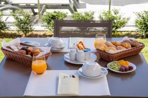 塔布阿Luna Hotel de Tábua的蓝色桌子,早餐食品篮和橙汁